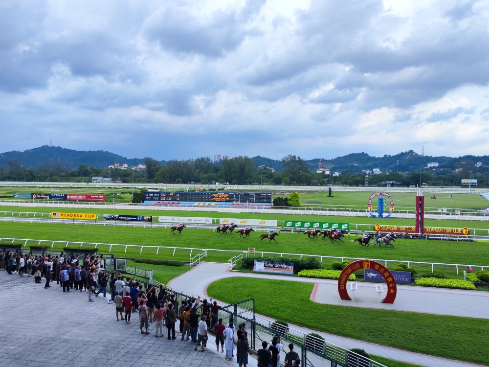 Horses race towards the finishing line during the Merdeka Cup at STC. — Picture by Kenneth Tee
