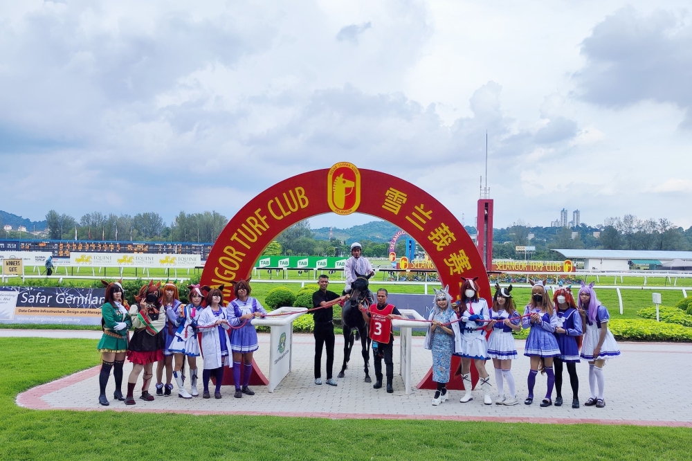 Umamusume cosplayers take a group photo with STC chairman Tan Sri Richard Cham Hak Lim and the winner of the Merdeka Cup during a prize-giving ceremony. — Picture by Kenneth Tee