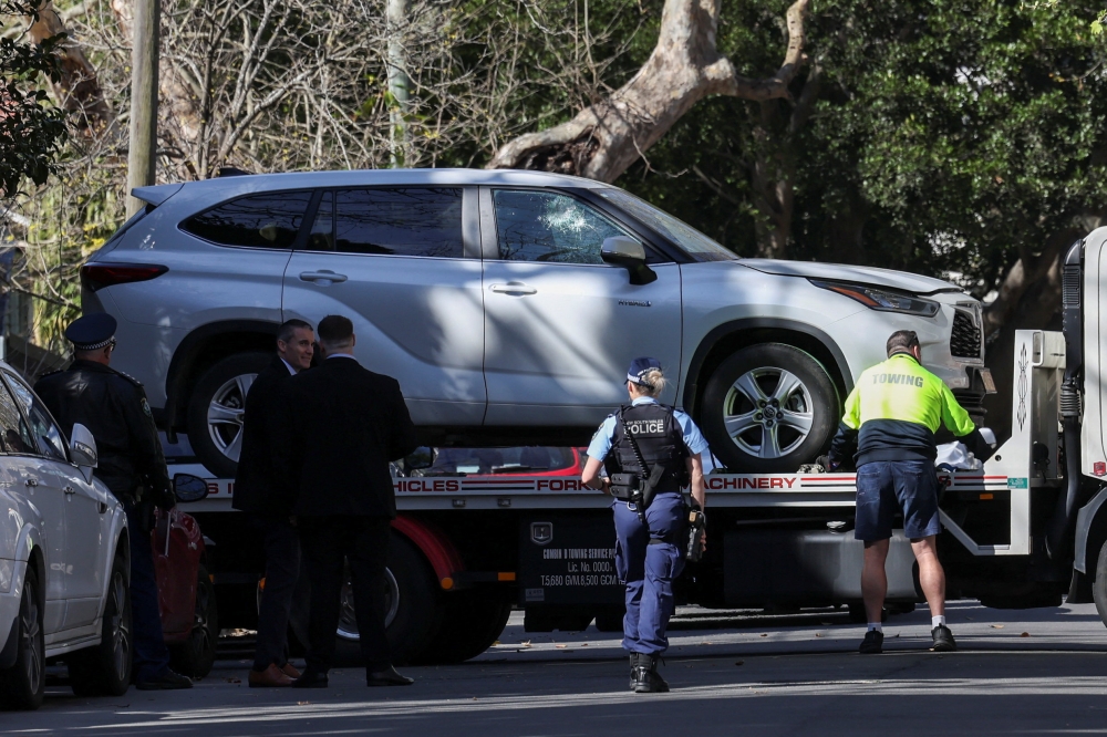 Police officers oversee the loading of a car with a smashed window onto a flatbed truck after it crashed into the Russian consulate in Sydney September 1, 2025. — Reuters pic