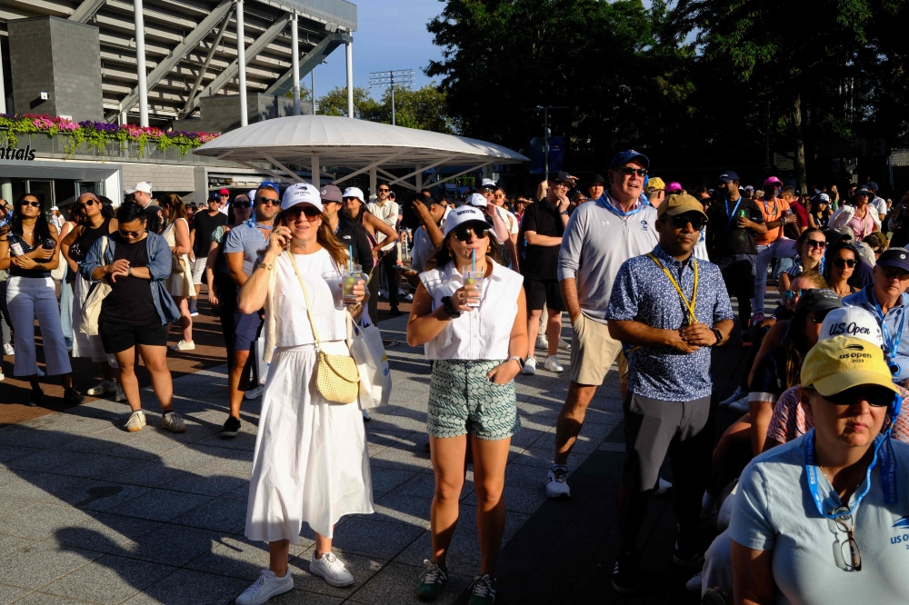 Attendees watch games on a screen on day eight of the US Open tennis tournament at the USTA Billie Jean King National Tennis Centre in New York City, on August 31, 2025. — AFP pic