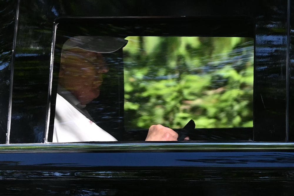 US President Donald Trump checks his phone as he departs from Trump National golf course in Sterling, Virginia on August 31, 2025, en route to the White House. — AFP pic