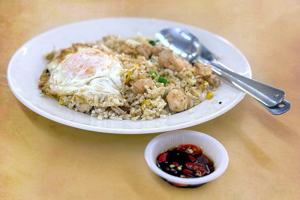 Fried rice with chicken, topped with a fried egg. — Picture by CK Lim