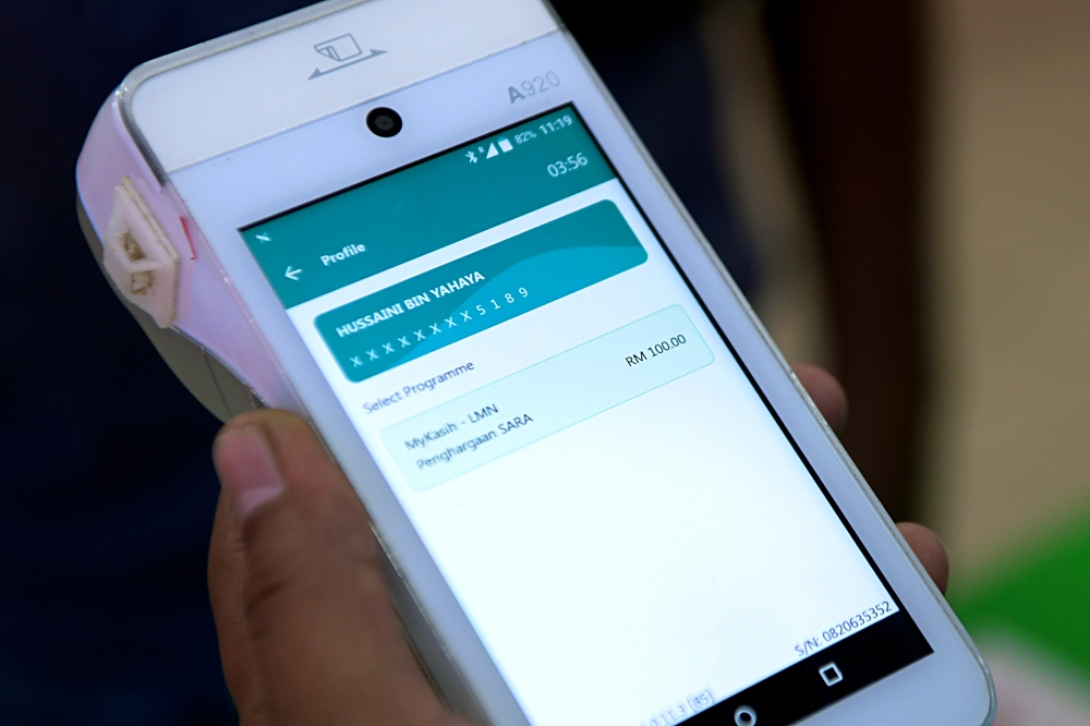 A cashier scans a customer’s MyKad to verify the RM100 Sumbangan Asas Rahmah (SARA) one-off aid at TF Value Mart. The special cashless aid, redeemable via MyKad for all Malaysians aged 18 and above, aims to ease living costs amid rising prices. — Bernama pic