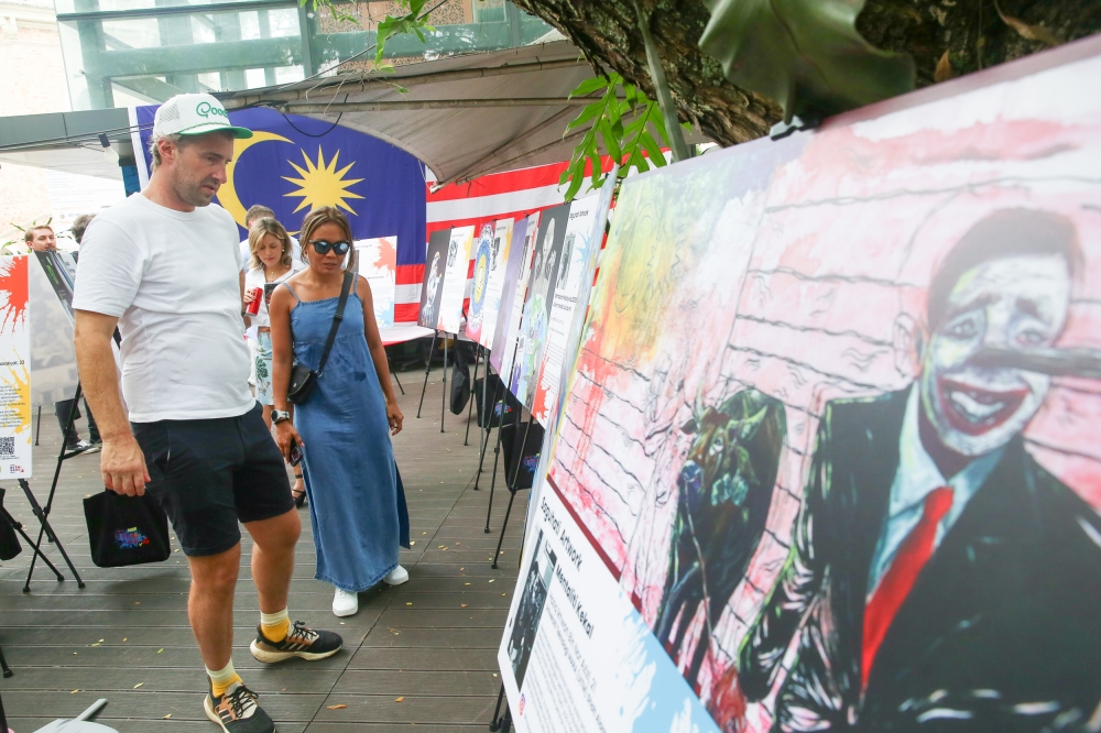 Tourists and locals give a long look at how tall tales grow taller, at the Bersama2050 Exhibition, at the river of life. — Picture by Choo Choy May