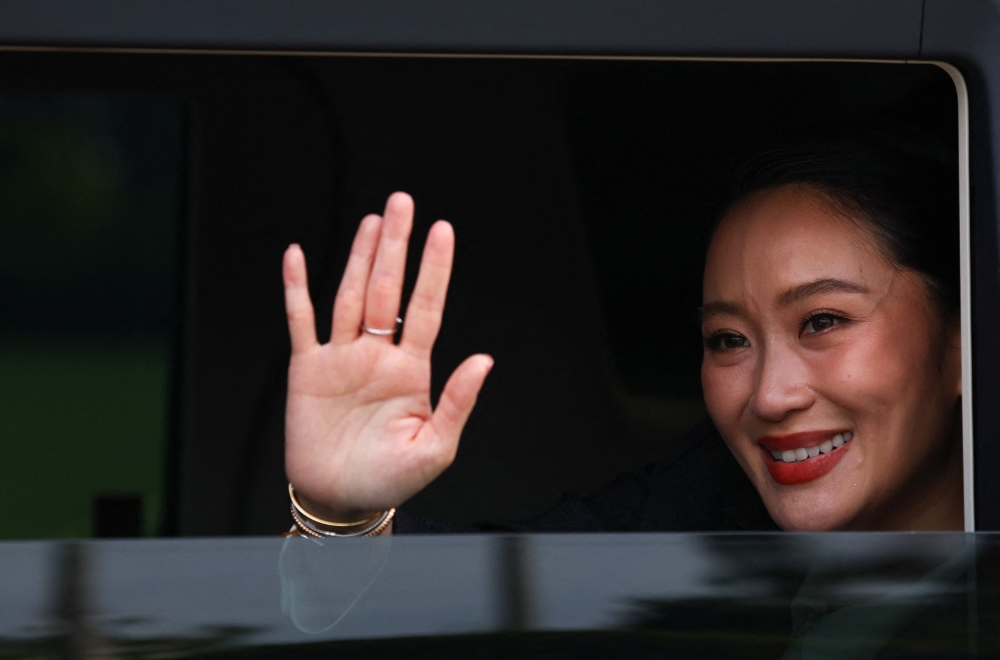 Thailand’s dismissed prime minister, Paetongtarn Shinawatra, waves from a vehicle as she leaves the Government House in Bangkok on August 29, 2025, after a Constitutional Court ruling removed her from office. — Reuters pic