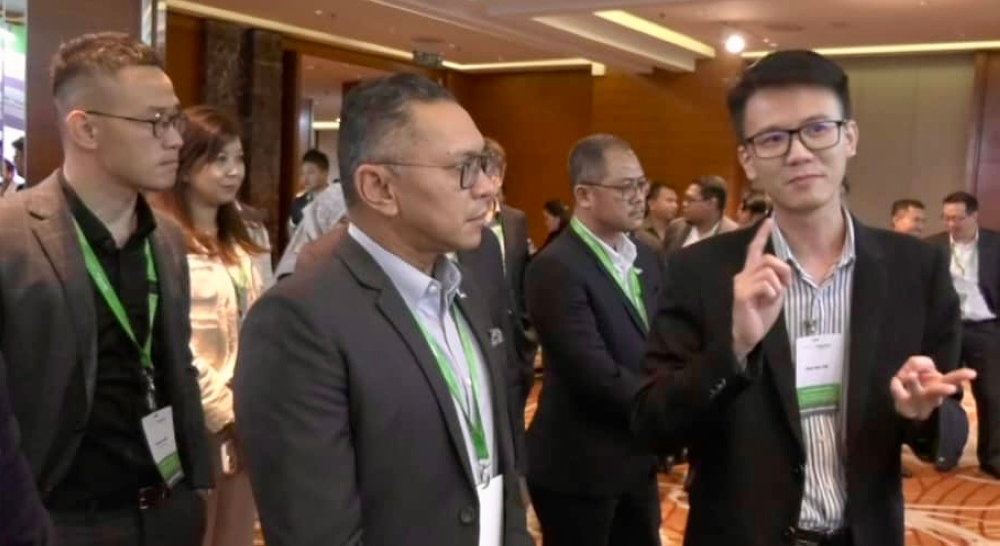 Johor Infrastructure Group’s managing director Datuk Mahadzir Aziz (centre) being briefed during his visit to the Innovation Day Johor 2025: Digital Transformation and Al for a Smart Johor programme in Johor Bahru today. — Picture by Ben Tan