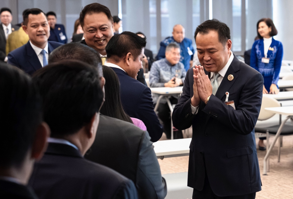 Bhumjaithai Party leader Anutin Charnvirakul (right) greets fellow MPs at the parliament in Bangkok on September 3, 2025. Thailand’s acting prime minister has moved to dissolve parliament, his party said on September 3, 2025 after the largest opposition party backed a rival candidate for prime minister. — AFP pic 