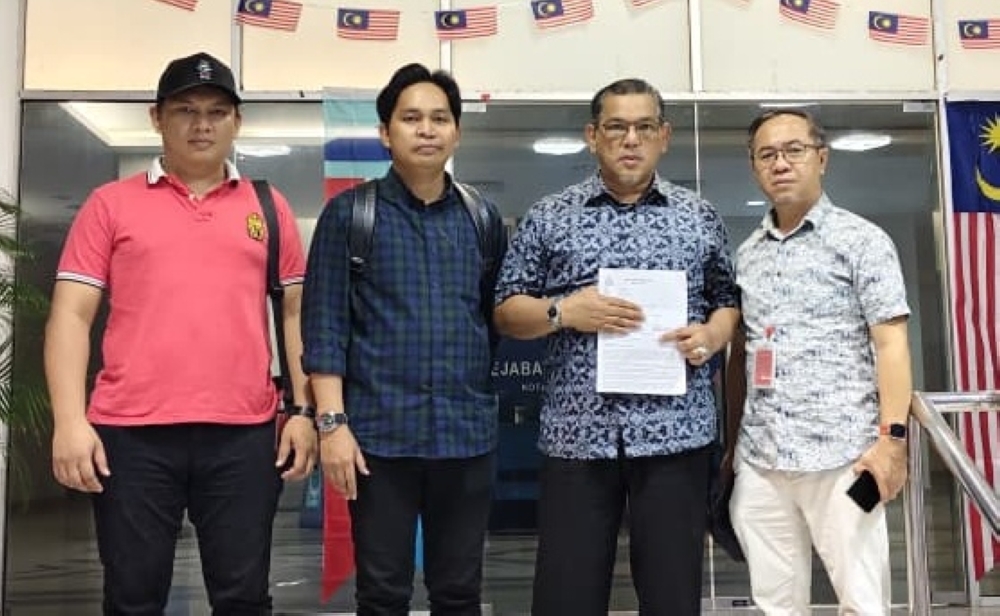 Parti Gagasan Rakyat Sabah information chief Datuk Nizam Abu Bakar Titingan (2nd right) after lodging the police report on Wednesday. — The Borneo Post pic 