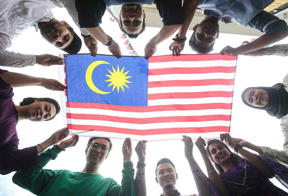 File photo of people holding the Jalur Gemilang August 21, 2023. Picture for illustration purposes only. — Picture by Farhan Najib