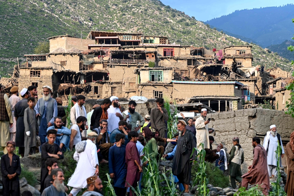 Afghans gather near damaged houses after earthquakes at Mazar Dara village in Nurgal district, Kunar province, in Eastern Afghanistan, on September 1, 2025. — AFP pic