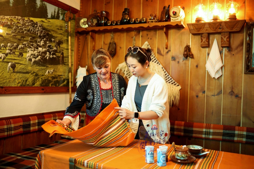 Rumiyana Cholakova, a local resident in the village of Momchilovtsi presents the process of yogurt making to a Chinese tourist in her home, in Momchilovtsi, Bulgaria, August 29, 2025. — Reuters pic