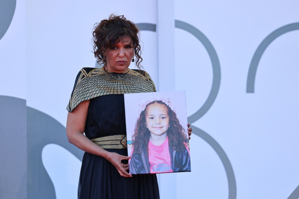 Kaouther Ben Hania poses with a picture of Hind Rajab on the red carpet during arrivals for the screening ‘The Voice of Hind Rajab’ in competition, at the 82nd Venice Film Festival, Venice September 3, 2025. The movie has yet to secure a US distributor, but Ben Hania said she remained hopeful. — Reuters pic