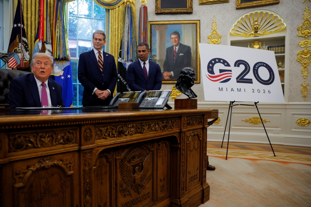 US President Donald Trump speaks next to a sign with a logo for the G20 summit 2026, accompanied by US Secretary of the Treasury Scott Bessent and Miami Mayor Francis Suarez, in the Oval Office, at the White House in Washington, D.C. September 5, 2025. — Reuters pic  