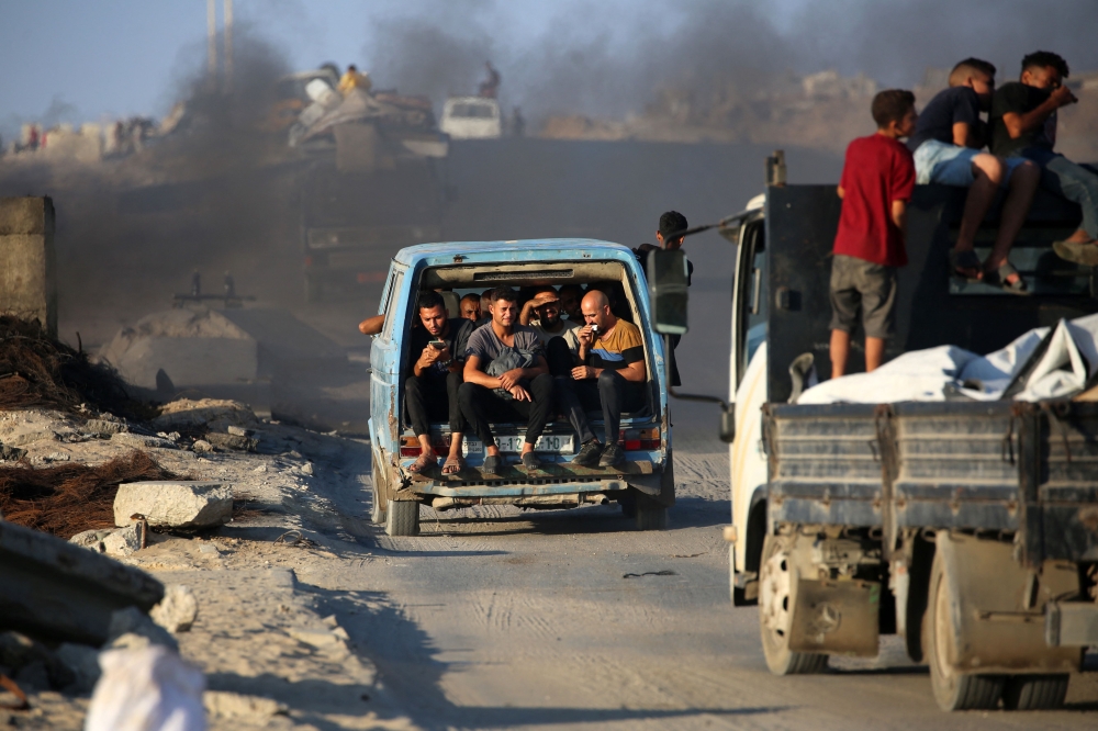 Palestinians fleeing south, ride vehicles with their belongings, on the coastal road near the Nuseirat refugee camp in the central Gaza Strip, on August 5, 2025. — AFP pic 
