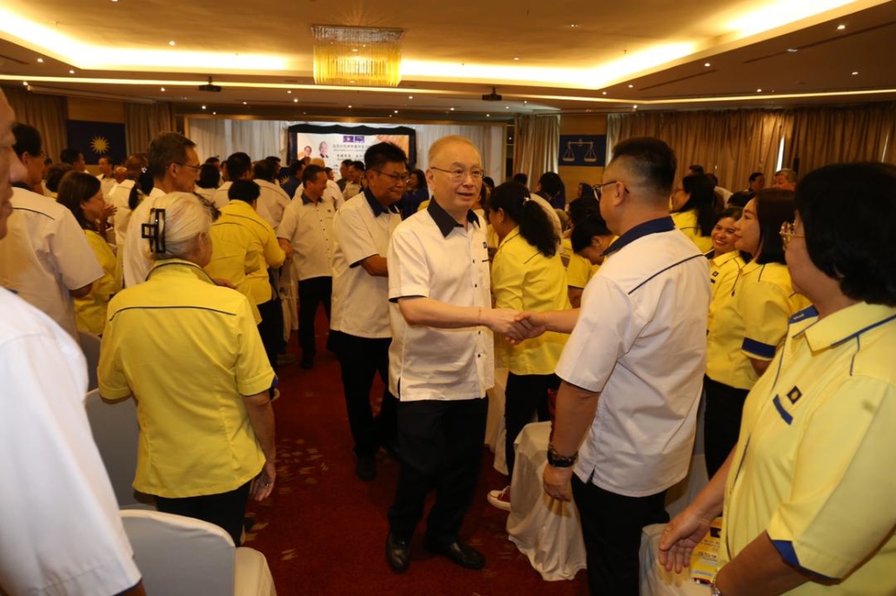 Wee exchanges greetings with Sabah MCA members attending the convention. — The Borneo Post pic