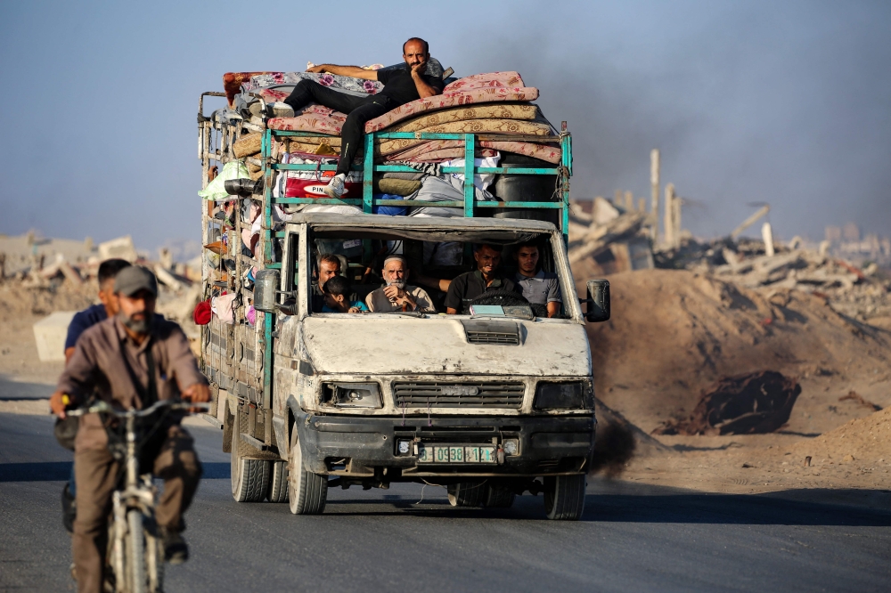 Palestinians fleeing south, ride a truck with their belongings, on the coastal road near the Nuseirat refugee camp in the central Gaza Strip, on August 5, 2025. Despite mounting pressure at home and abroad to halt its nearly two-year offensive in Gaza, Israel has been calling up reservists, intensifying its bombardments and closing in on Gaza City ever since announcing its intention to capture the Palestinian territory's largest city. — AFP pic