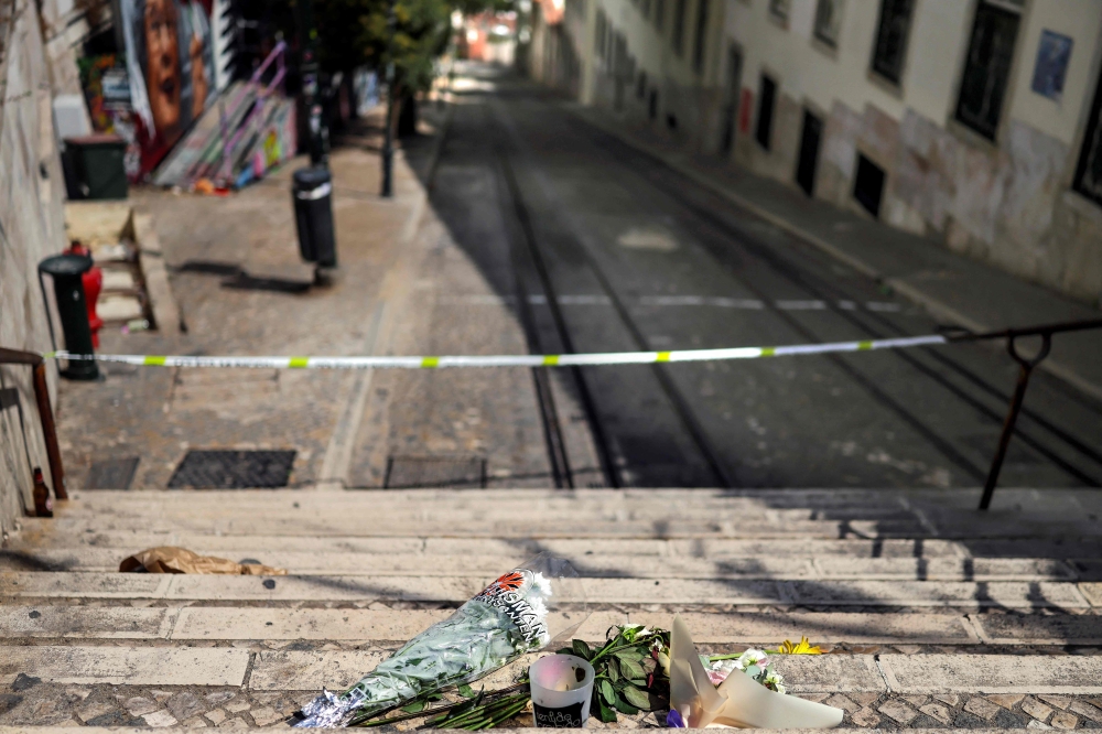 Flowers and tributes are pictured up the stairs at the site of the Gloria funicular accident after the wreckage was removed in Lisbon on September 5, 2025. — AFP pic 