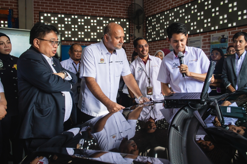Digital Minister Gobind Singh Deo (second left) looks at vehicle data forensics equipment during the launch of the Vehicle Forensics Laboratory at CyberSecurity Malaysia in Menara Cyber Axis, Cyberjaya, September 8, 2025. Also present is the ministry’s secretary-general Fabian Bigar (left). — Bernama pic