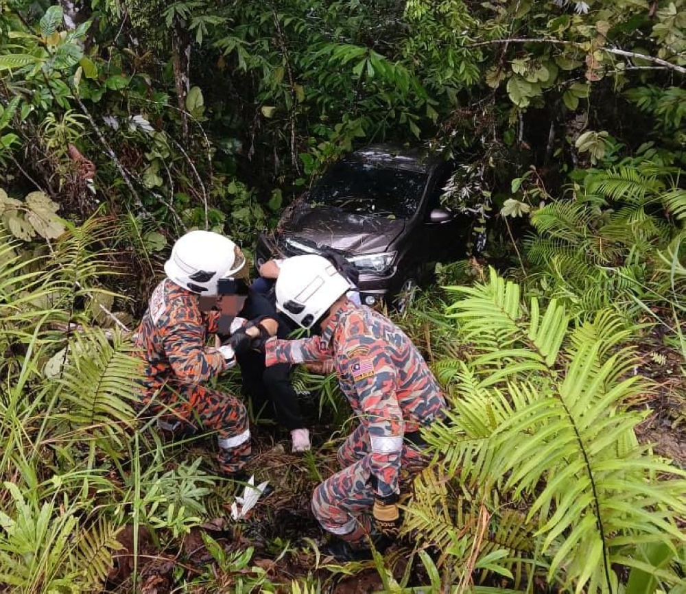 A 43-year-old woman injured her shoulders after she crashed her vehicle down a gorge at Kampung Belimbing, Jalan Krokong in Bau this morning. — The Borneo Post pic