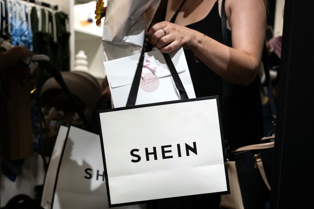 A customer holds her bags as she leaves a pop-up store of the Chinese fast fashion brand Shein, in Dijon on June 26, 2025.— AFP pic