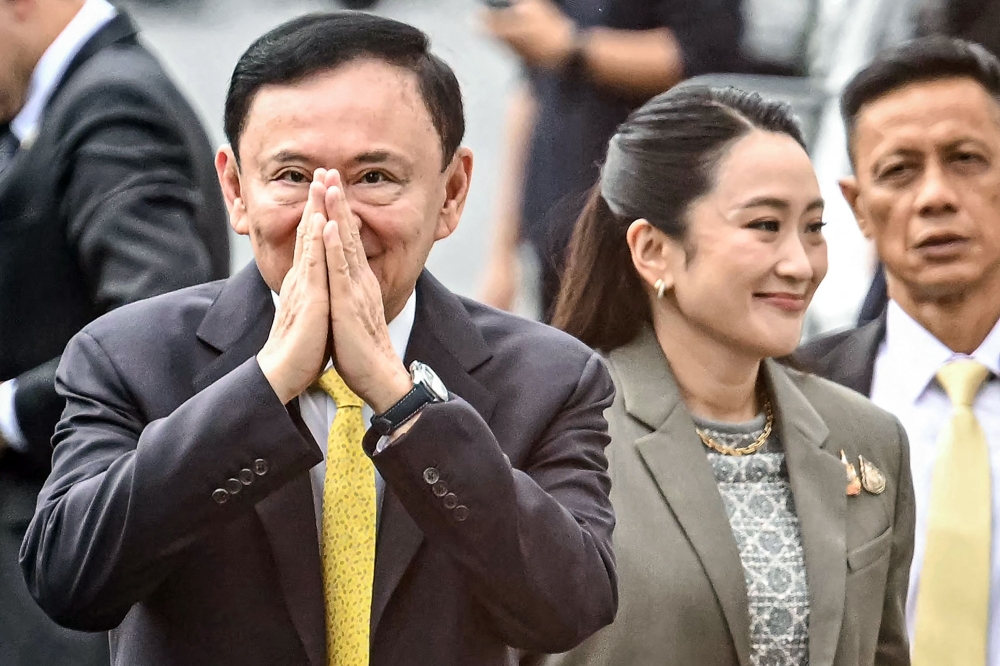 Thailand’s former prime minister Thaksin Shinawatra arrives with his daughter Thailand’s sacked prime minister Paetongtarn Shinawatra (right) at the Supreme Court in Bangkok September 9, 2025. — AFP pic