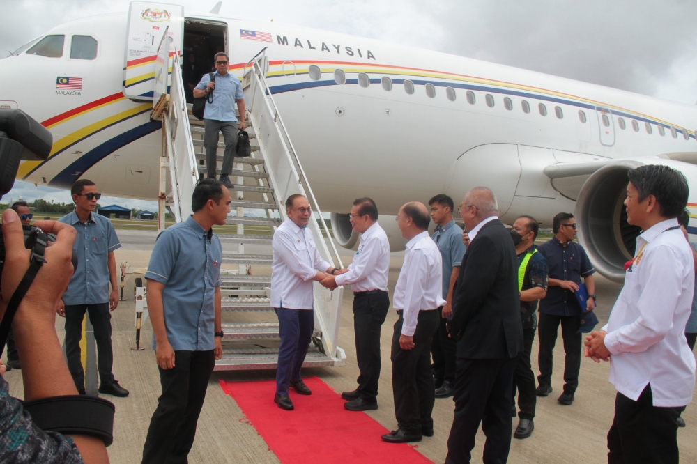 State Minister of Transport Datuk Seri Lee Kim Shin welcomes Anwar upon his arrival at Miri Airport. — The Borneo Post pic