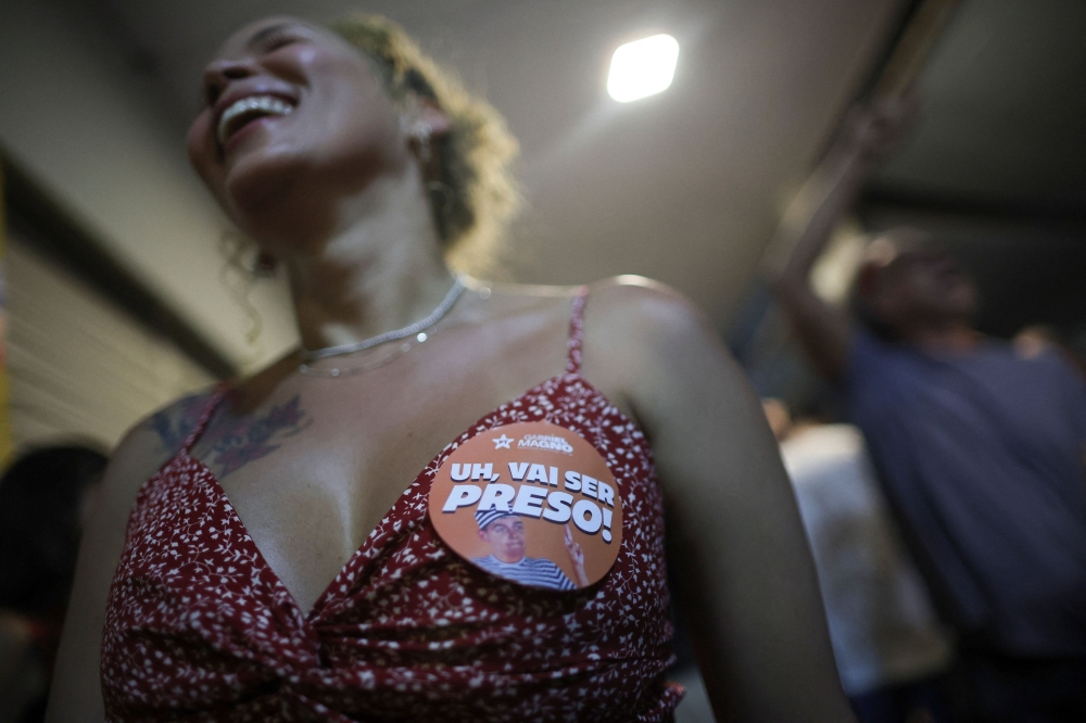 A woman smiles with a sticker reading “Uh, you’re going to get arrested” while celebrating the conviction of former Brazilian president Jair Bolsonaro in Brasilia, Brazil, on September 11, 2025. — Reuters pic