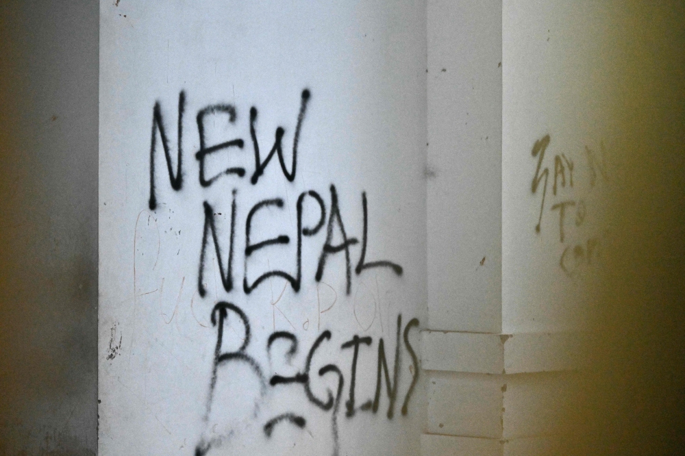 Graffiti is seen on the wall of the Singha Durbar, the main administrative building for the Nepal government, after it was set ablaze by protesters, in Kathmandu on September 11, 2025. — AFP pic