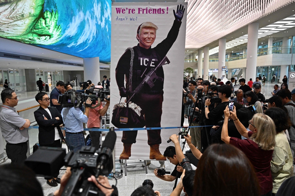 A protester displays a banner with a depiction of US President Donald Trump at Incheon International Airport in Incheon on September 12, 2025. — AFP pic