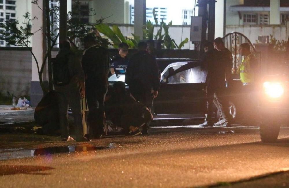 Police investigate the scene of a stabbing in Taman Nona, Guar Chempedak, where a woman was found dead inside a Proton Wira. — Picture via Facebook