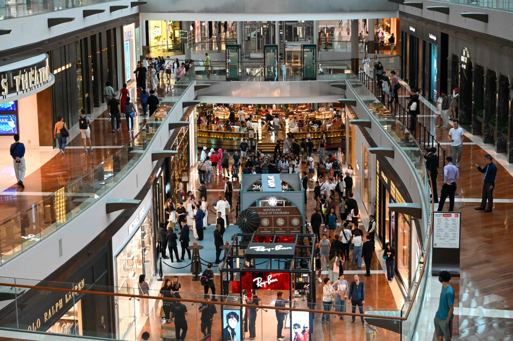 Visitors walk through the Marina Bay Sands shopping mall in Singapore September 11, 2025. — AFP pic