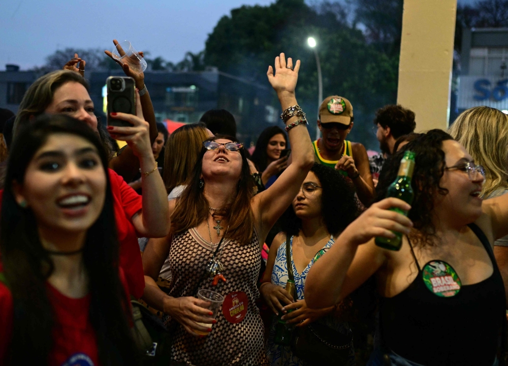 People celebrate the Brazilian Supreme Court's decision on former president Jair Bolsonaro's trial in Brasilia on September 12, 2025. — AFP pic