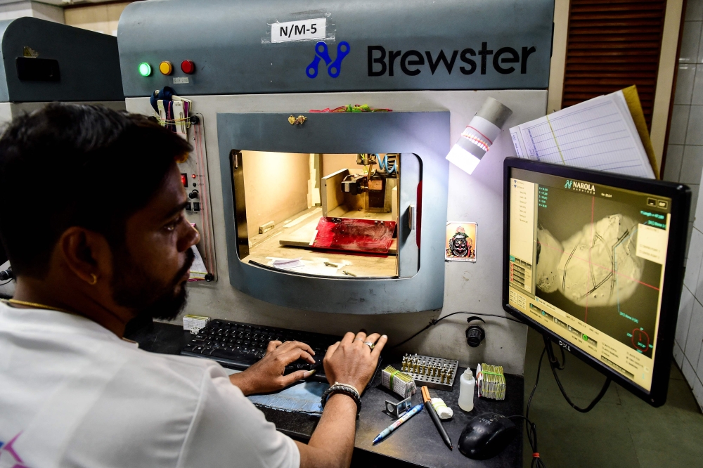 This photograph taken on February 7, 2024 shows an employee working at HVK International, a firm manufacturing natural diamonds in Surat. — AFP pic