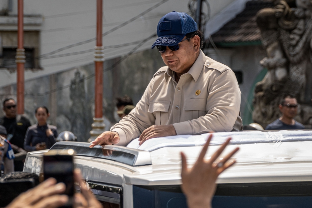 Indonesia’s President Prabowo Subianto greets residents during a visit to a flood-affected area in Denpasar, Bali, on September 12, 2025. — AFP pic