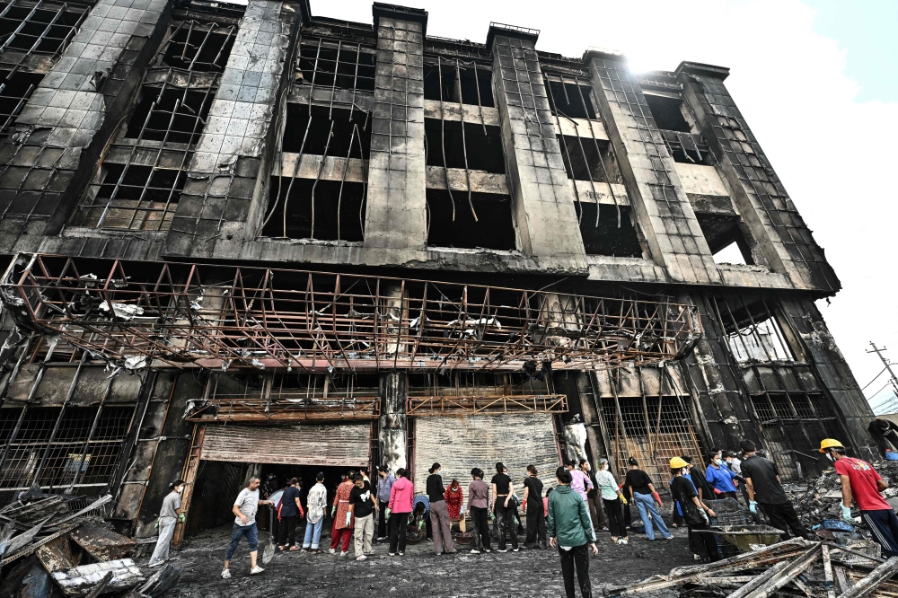 Local residents clean up the rubble of a burnt supermarket that was set ablaze during protests in Kathmandu on September 13, 2025. — AFP pic