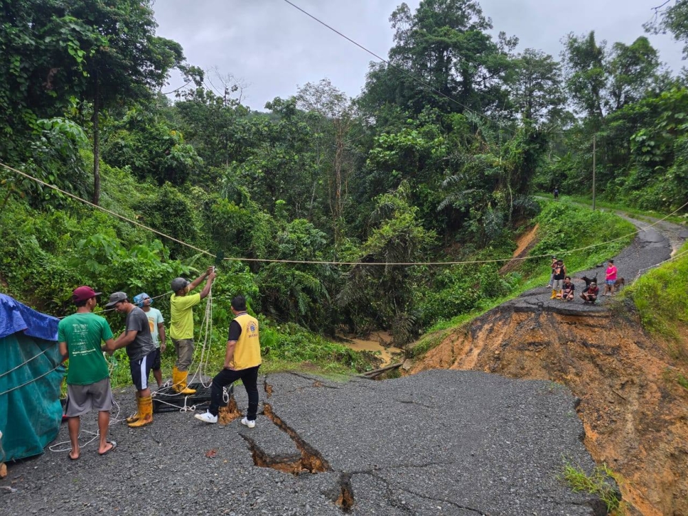 Volunteers deliver food and water to stranded Penampang residents after landslides and heavy rain cut off roads. — Picture from Facebook/Randolf Paza