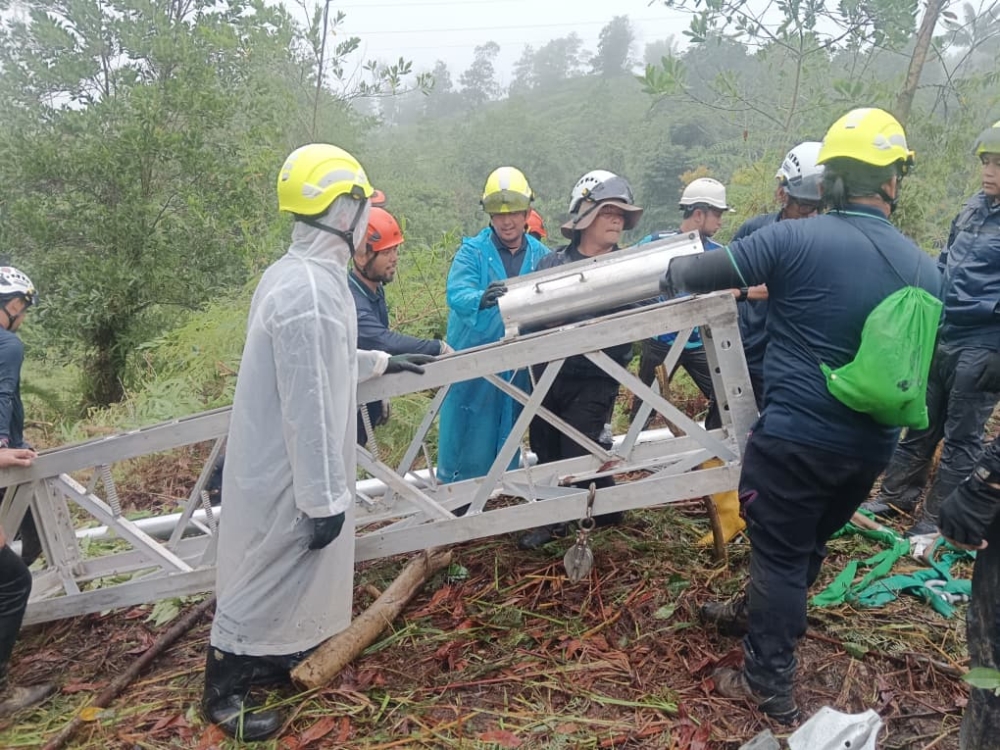 Technical teams from Sabah Electricity Sdn Bhd (SESB) are working around the clock to repair a collapsed transmission tower in Kampung Sarapung, Penampang, despite heavy rain and difficult access to the site. — The Borneo Post pic