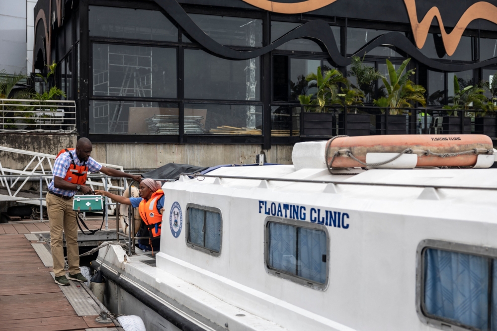 Ibrahim Famuyiwa, head of operations at the Lagos State Waterways Authority, receives a hard-shell first aid box from a colleague on the Lagos State floating clinic, docked at the LASWA boat jetty in Lagos, on August 26, 2025. — AFP pic 
