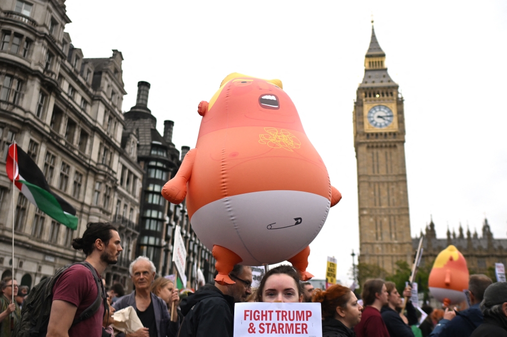 Protesters carry placards and a large inflatable orange baby as they march through Parliament Square with the Houses of Parliament in the background in London on September 17, 2025 during a national march organised by the Stop Trump Coalition against the State Visit of US President Donald Trump. — AFP pic 
