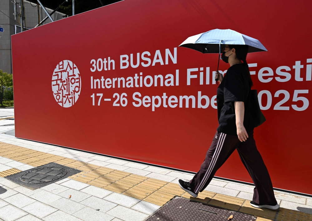 A woman walks past a sign for the 30th Busan International Film Festival (BIFF) at the Busan Cinema Center in Busan on September 17, 2025. — AFP pic