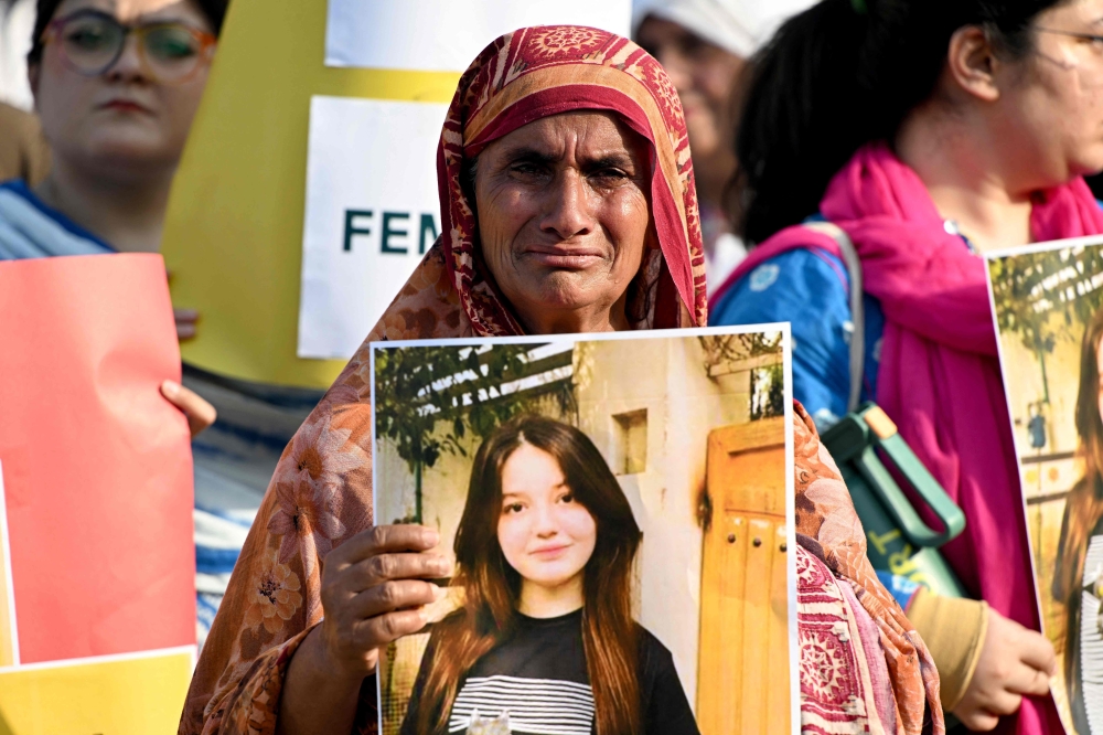 A woman weeps as she holds a poster of TikTok star Sana Yousaf during a protest held to condemn violence against women after Yousaf was killed for rejecting a man’s proposal in Islamabad June 5, 2025. — AFP pic