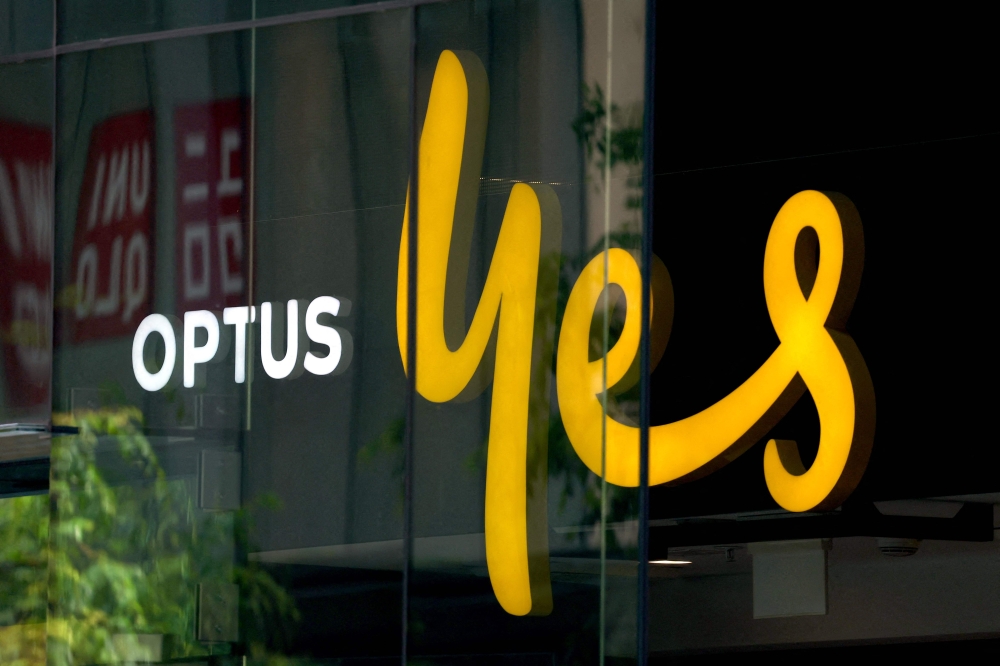 This file photo taken on November 9, 2023 shows an illuminated sign displayed in the window of an outlet for the Australian communications company Optus in Sydney. — AFP pic