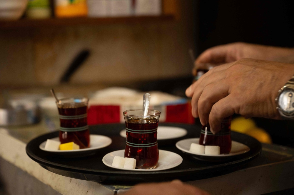 A waiter prepares black tea at a tea house in the town of Vushtrri. — AFP pic