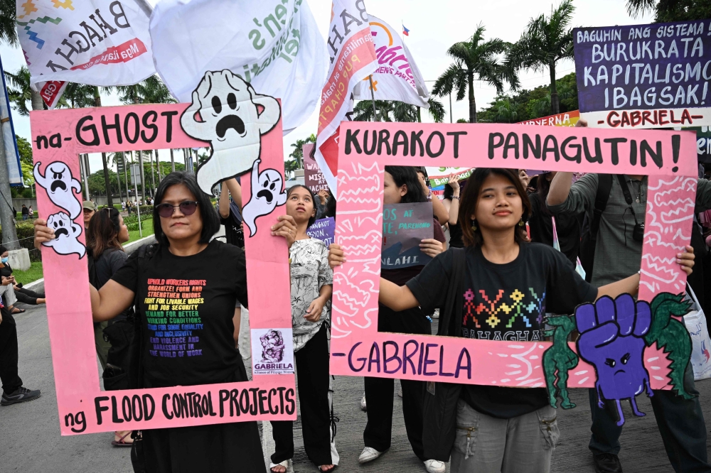 Protesters hold placards, one (right) which reads ‘The corrupt should be made answerable’, during a rally against phony flood control projects in Manila September 21, 2025. — AFP pic