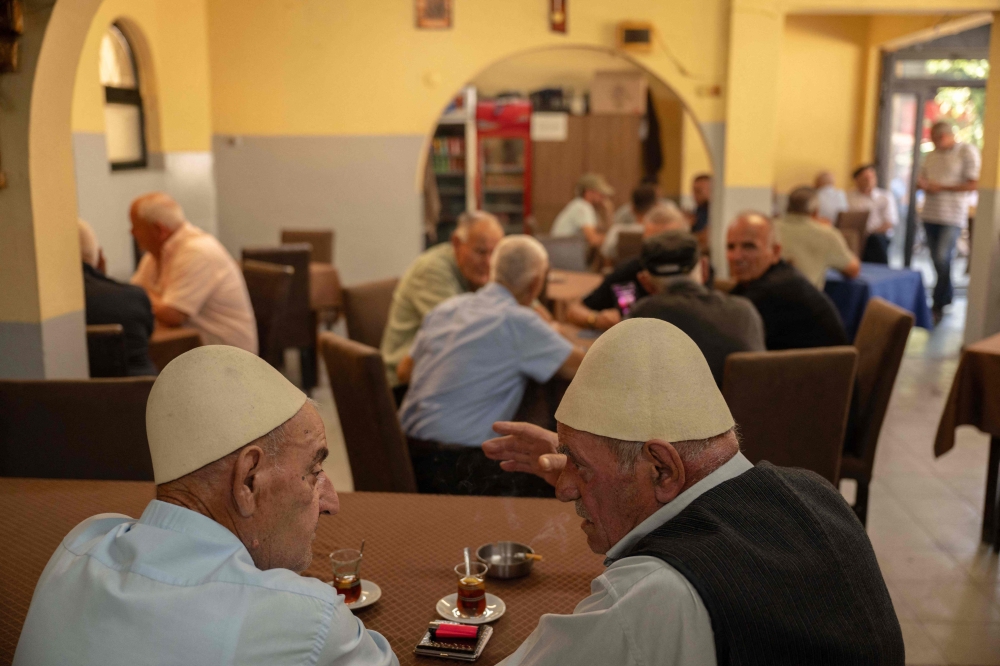 Patrons drink black tea at a tea house in the town of Vushtrri on August 16, 2025. — AFP pic