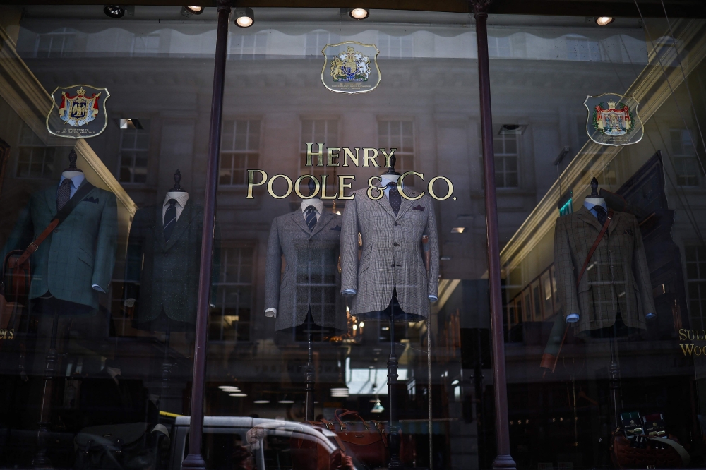 Suits on display inside the window of Henry Poole & Co on Savile Row in London on August 12, 2025. Beneath the old-world exterior of a tailors on London's famed Savile Row, the workshop where the magic happens is more youthful than ever as aspiring coatmakers vie for competitive apprenticeships. — AFP pic 