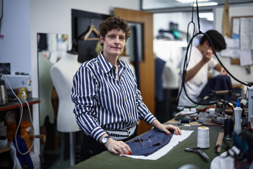 Coat maker Jinny Seals poses at a workstation inside Henry Poole & Co on Savile Row in London on August 12, 2025. — AFP pic 
