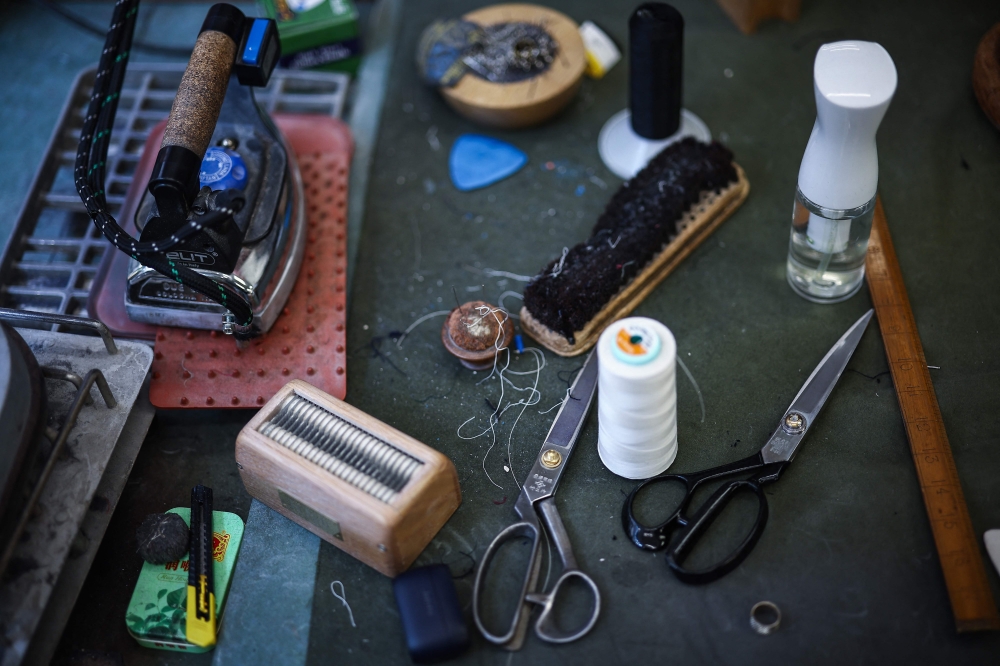 Various items used by a tailor lie on a work top inside Henry Poole & Co on Savile Row in London on August 12, 2025. — AFP pic 