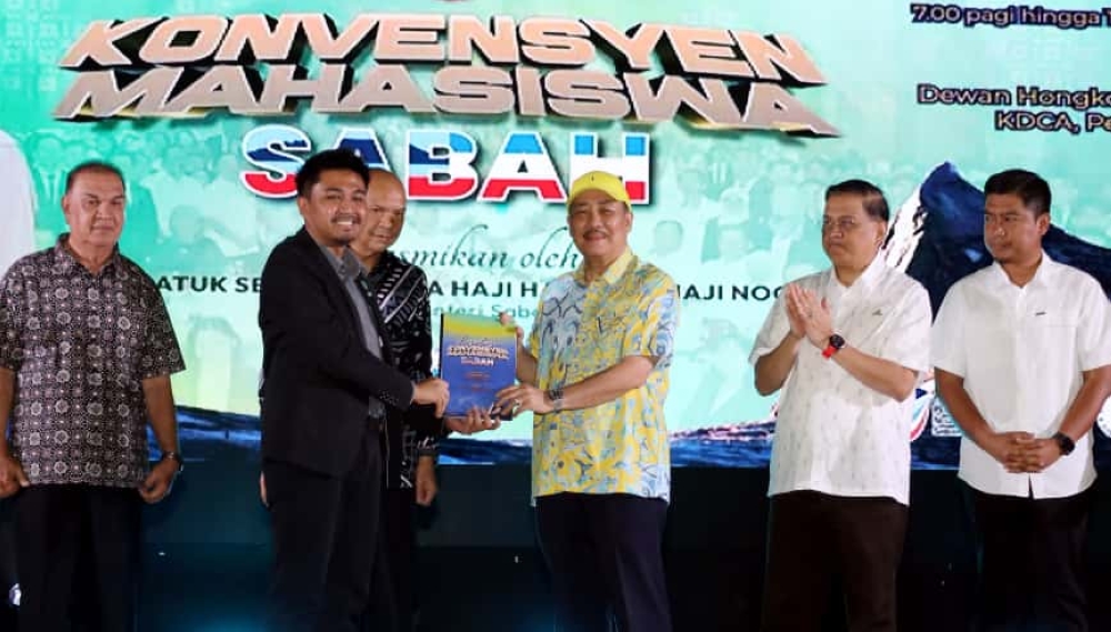 Chief Minister Datuk Seri Panglima Hajiji Noor receives the resolutions adopted at the convention. — The Borneo Post pic