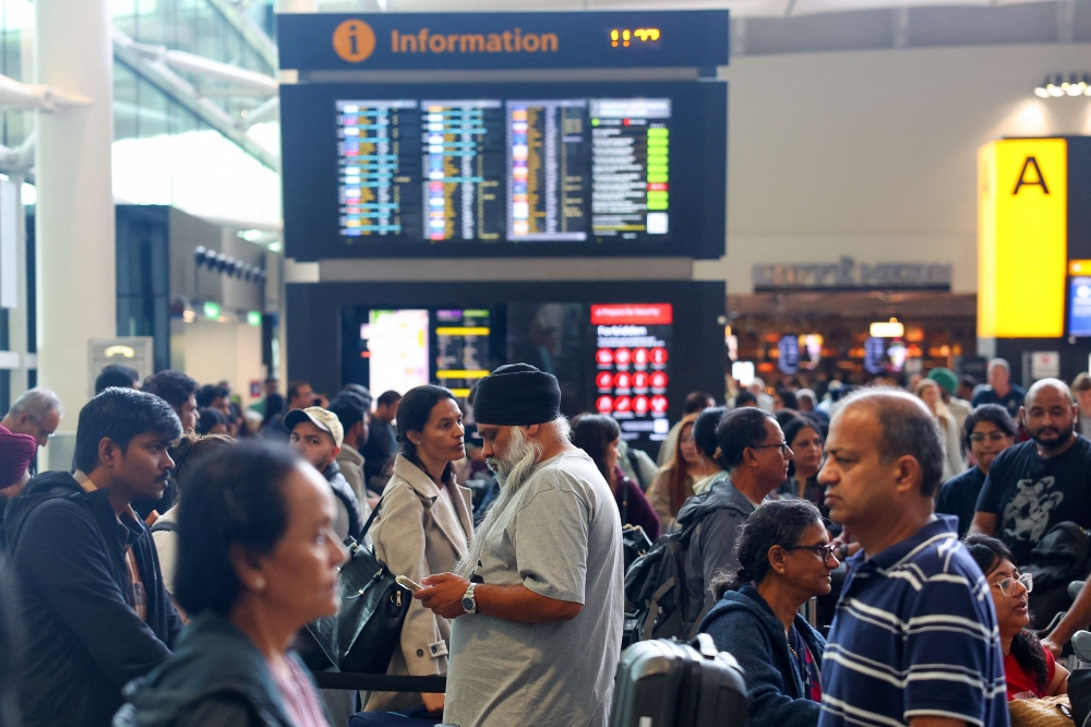 Travellers wait near check-in desks at Heathrow Airport Terminal 2, amid flight delays and cancellations, resulting from a disruption to check-in and boarding systems caused by a cyberattack which has affected several major European airports, in Greater London September 20, 2025. — Reuters pic